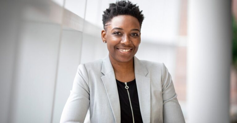 Confident African American businesswoman smiling inside a modern office space.